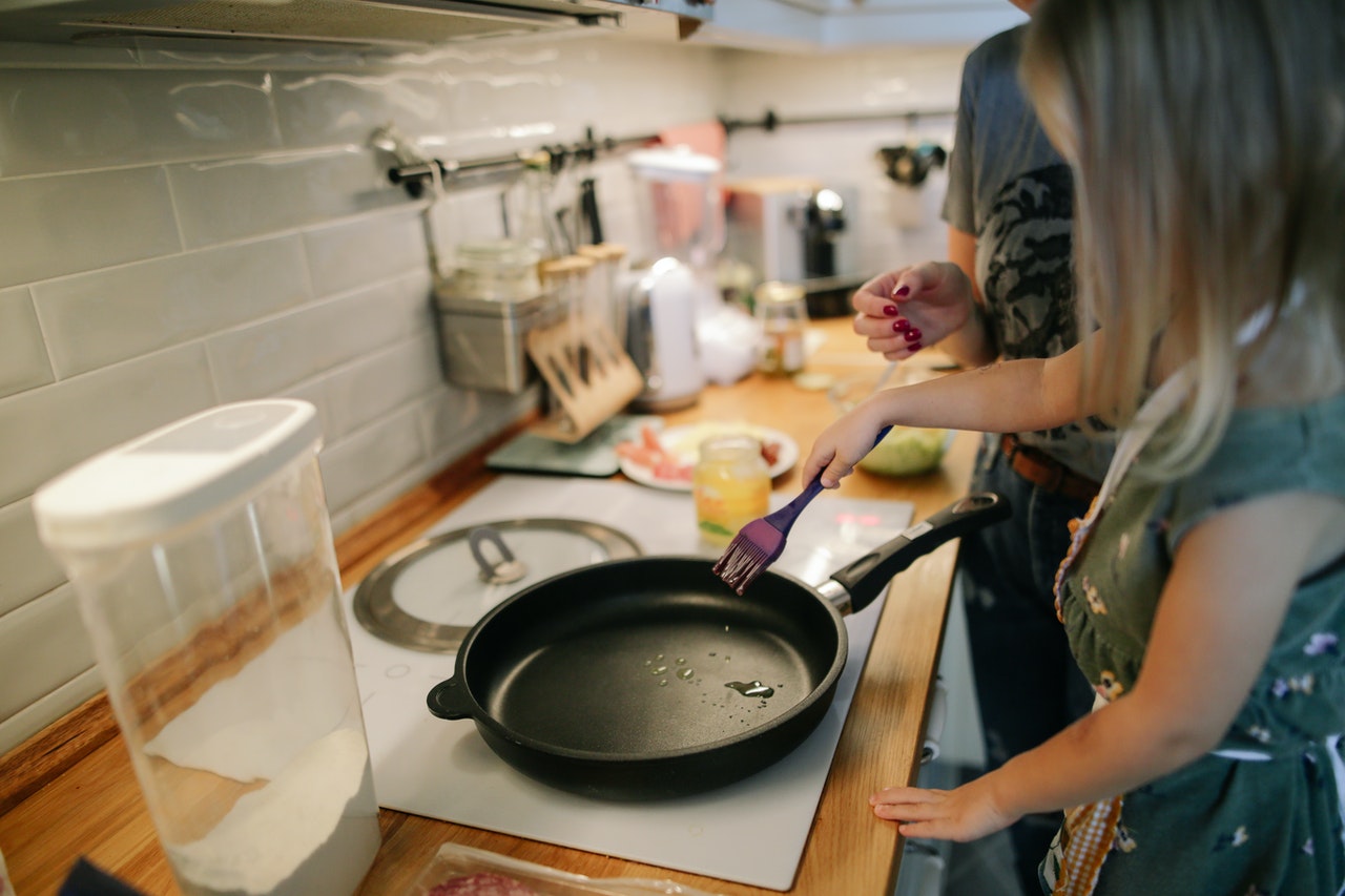 Barn er med til at lave mad i køkkenet